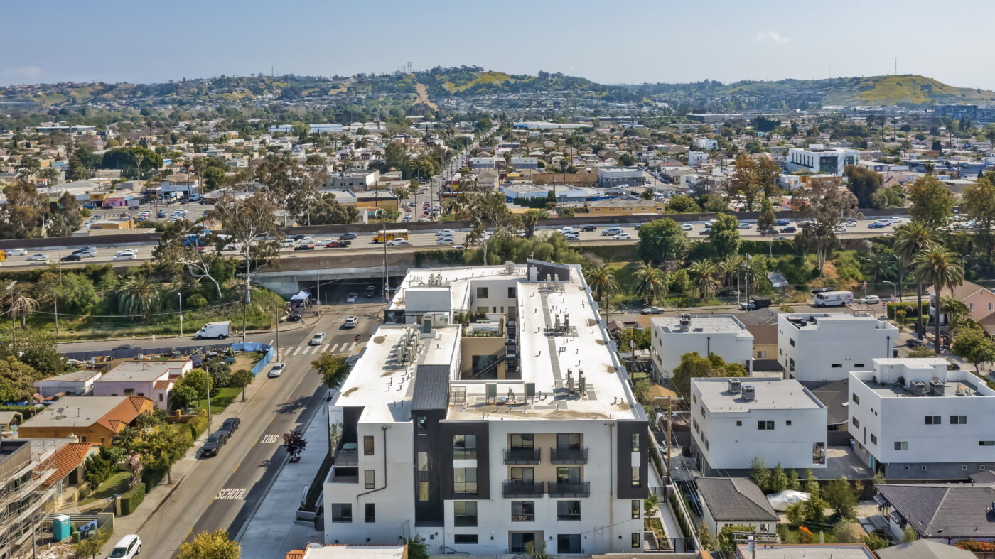 Aerial view of building showing surrounding streets with hills in the distance
