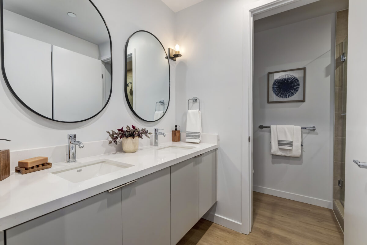 bathroom with double vanity and shower stall